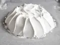 Idealna beza pavlova, która zawsze wychodzi, z puszystą pianką uformowaną na papierze do pieczenia.