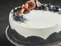 Wykwintny tort makowy z kremem kawowym, ozdobiony świeżymi figami i jagodami.