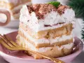 Puszyste ciasto balowe z kremem i kakao, gotowe do degustacji. Złoty widelec czeka na pierwszy kęs.