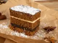 Puszysty piernik z powidłami i kremem, posypany cukrem pudrem. Idealny na święta, oto puszysty piernik przepis.