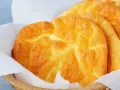 Puszyste, złociste **cloud bread** w koszyku wyłożonym papierem. Wyglądają jak chmurki!