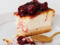 Pyszny kawałek sernika z wiśniami, idealny jako frużelina wiśniowa do tortu. Złota łyżeczka czeka na ostatni kęs.