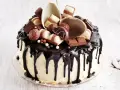 Wyjątkowy tort kinder bueno, oblany czekoladą, ozdobiony pralinkami i kawałkami batoników.