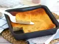 Pyszny, złocisty bread pudding wprost z blachy, podany na paterze. Idealny na deser.