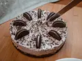 Nóż kroi pyszny tort oreo, ozdobiony ciasteczkami i posypką.