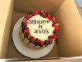 Ozdobiony owocami tort z napisem "Dziękujemy, że jesteś". Wskazówka, jak zrobić napis na torcie.