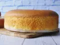 Puszysty, wilgotny biszkopt na drewnianej desce, gotowy do dekoracji.