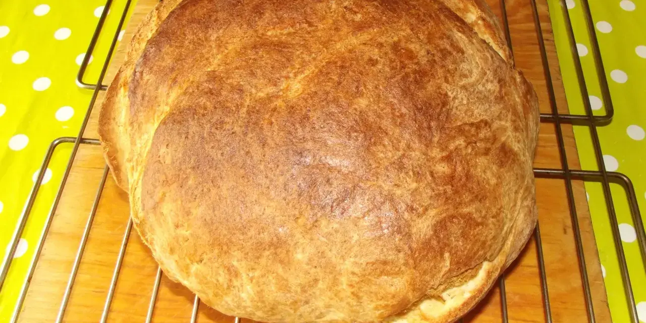 Pyszny, złocisty chleb z ziemniakami, świeżo wyjęty z pieca, stygnie na kratce.