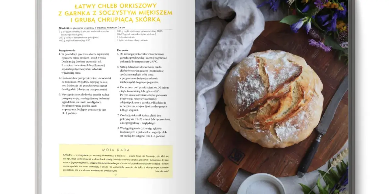 Chleb orkiszowy na zakwasie, lekko oprószony mąką, leży na desce obok noża. Wskazówki, dlaczego chleb się klei do noża, znajdziesz w przepisie.