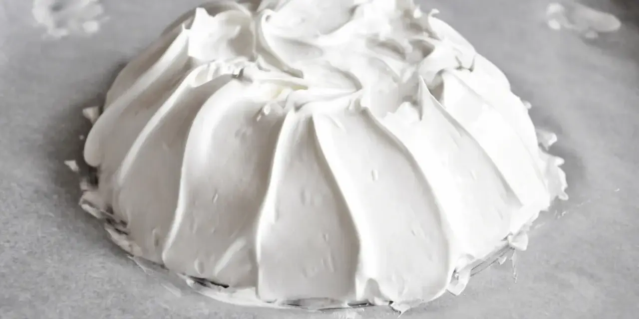 Idealna beza pavlova, która zawsze wychodzi, z puszystą pianką uformowaną na papierze do pieczenia.