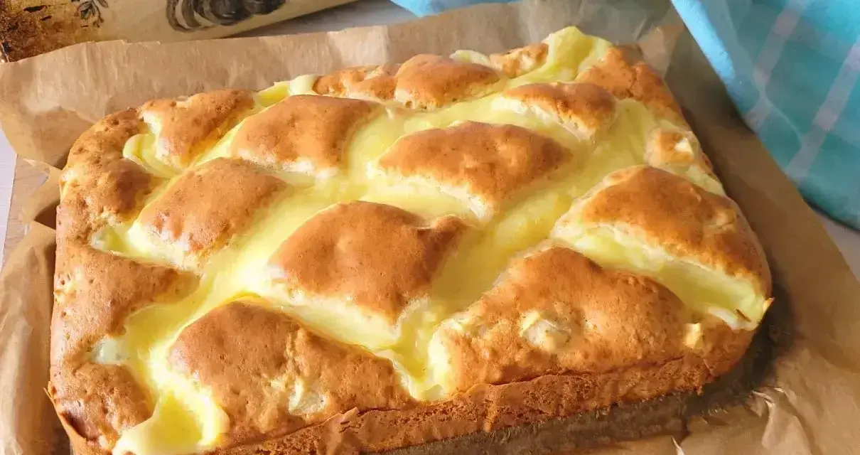 Puszyste ciasto jogurtowe z kremowym nadzieniem, upieczone na papierze do pieczenia.