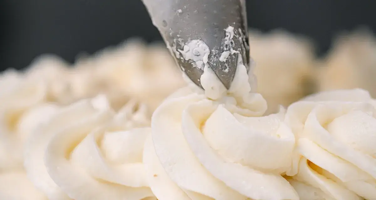 Dekorowanie tortu puszystym kremem bananowym za pomocą rękawa cukierniczego.