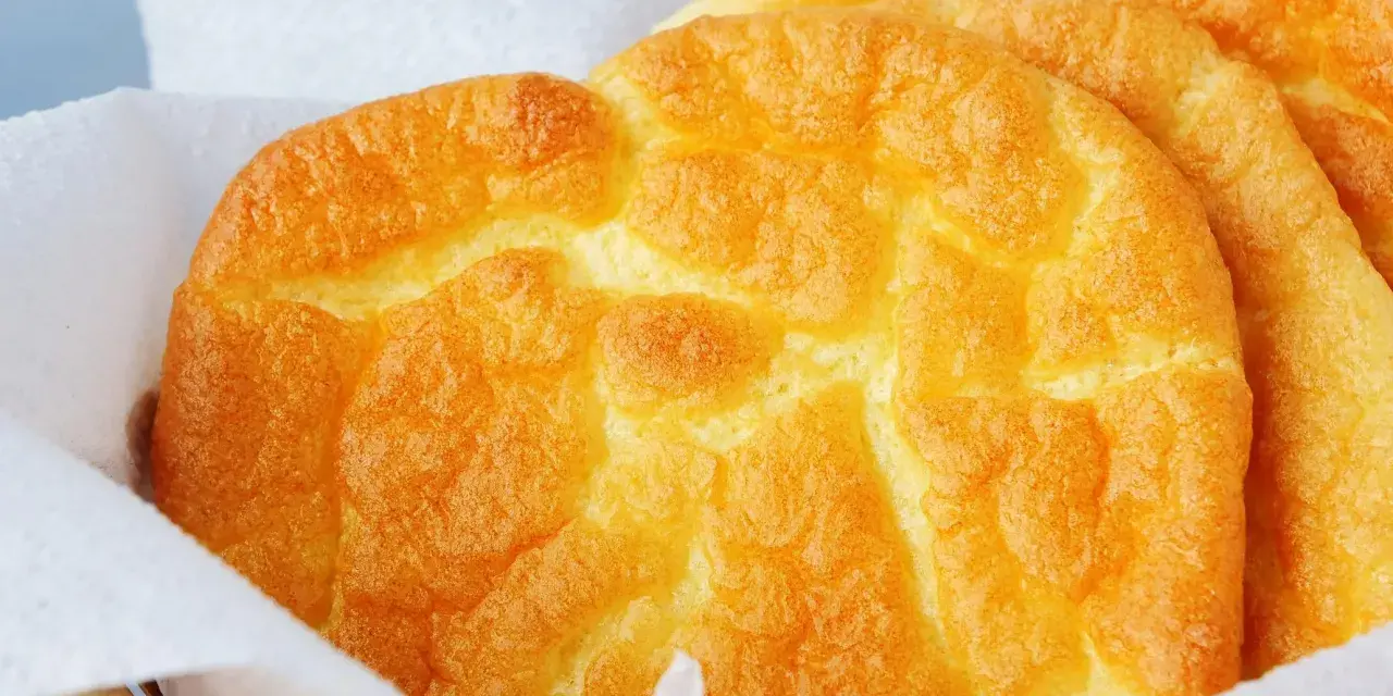 Puszyste, złociste **cloud bread** w koszyku wyłożonym papierem. Wyglądają jak chmurki!