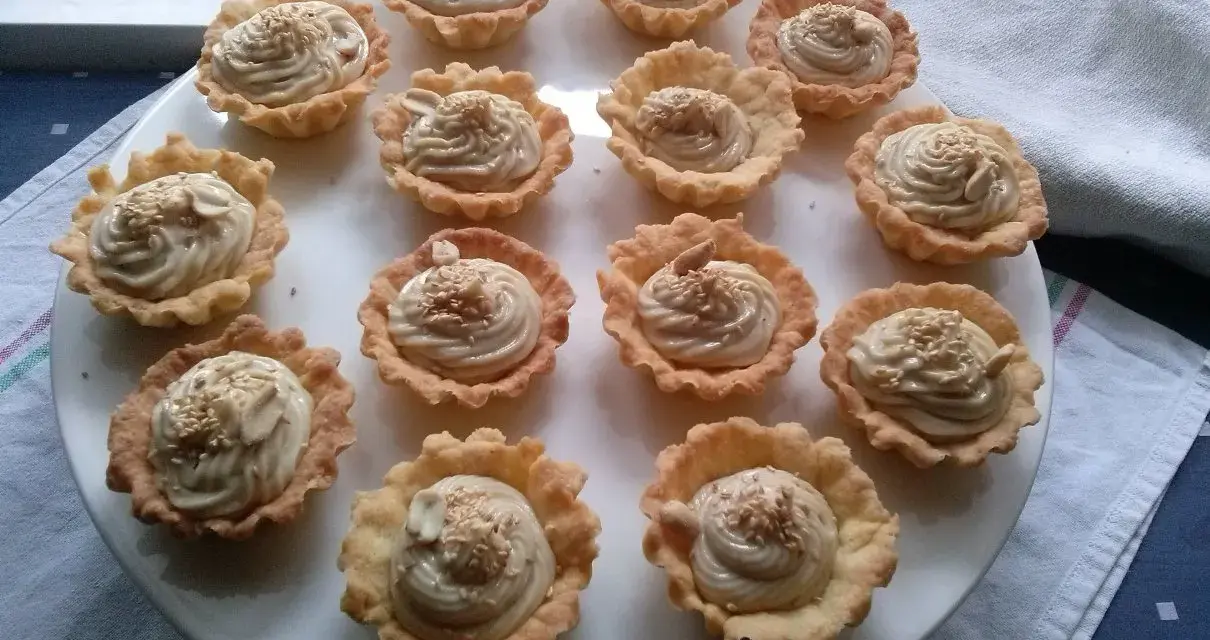Mini tartaletki z kremem chałwowym, posypane sezamem i orzechami. Idealne na deser.