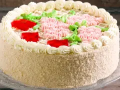 Kolorowy tort z kremem, galaretką i kwiatkami z kremu. Idealny, by czym przełożyć tort dla dzieci na przyjęcie.