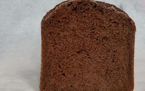 Kawałek ciemnego, puszystego chleba czekoladowego z widocznymi porami. Idealny na słodkie śniadanie.