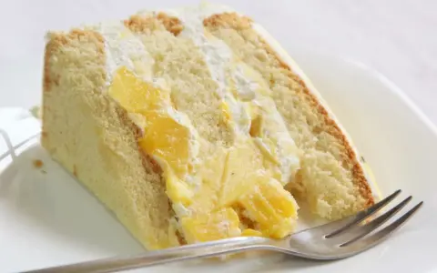 Puszysty biszkopt przełożony kremem i kawałkami mango. Ten tort mango wygląda pysznie!