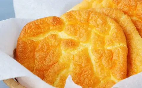 Puszyste, złociste **cloud bread** w koszyku wyłożonym papierem. Wyglądają jak chmurki!