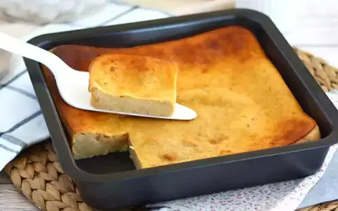 Pyszny, złocisty bread pudding wprost z blachy, podany na paterze. Idealny na deser.