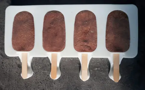 Czekoladowe cakesicles w formie lodów na patyku, gotowe do dekoracji. Idealny przepis na słodką przekąskę.