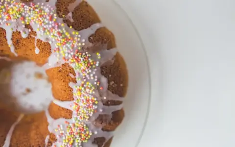 Babka z kolorową posypką, polana białym lukrem. Idealna na święta.