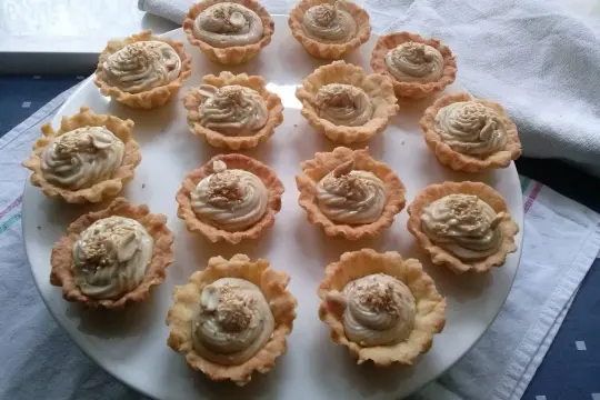 Mini tartaletki z kremem chałwowym, posypane sezamem i orzechami. Idealne na deser.