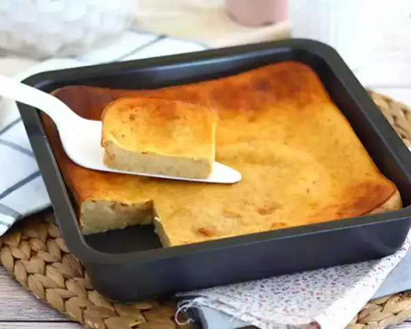 Pyszny, złocisty bread pudding wprost z blachy, podany na paterze. Idealny na deser.