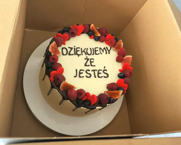 Ozdobiony owocami tort z napisem "Dziękujemy, że jesteś". Wskazówka, jak zrobić napis na torcie.