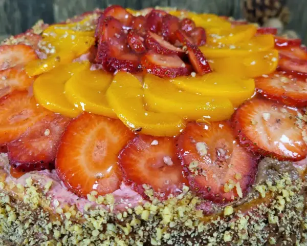 Pyszny tort z truskawkami i brzoskwiniami, ozdobiony orzechami. Idealny przepis na to, jak zrobić tort, który zachwyci każdego!