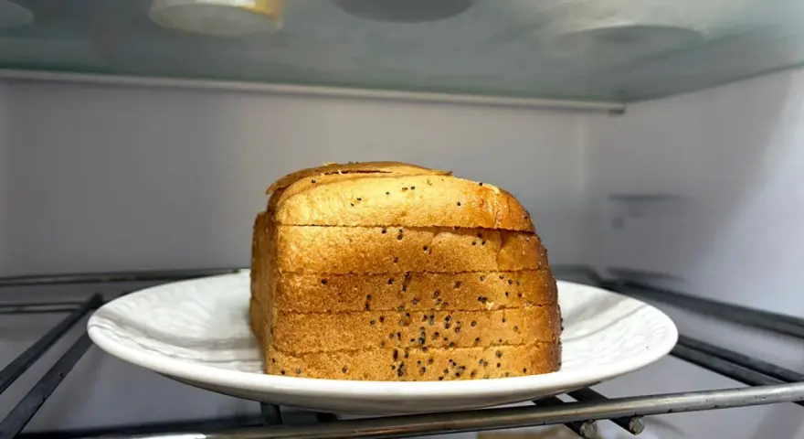 Kromki chleba na talerzu w lodówce. Czy można trzymać chleb w lodówce? To pytanie nurtuje wielu.