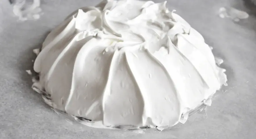 Idealna beza pavlova, która zawsze wychodzi, z puszystą pianką uformowaną na papierze do pieczenia.