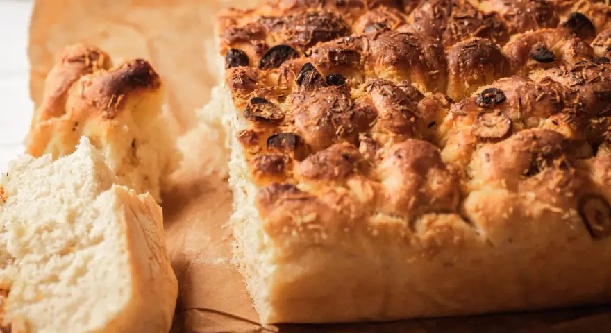 Puszysta focaccia z oliwkami i rozmarynem, idealna do podania. Ten przepis na focaccię jest prosty i szybki.