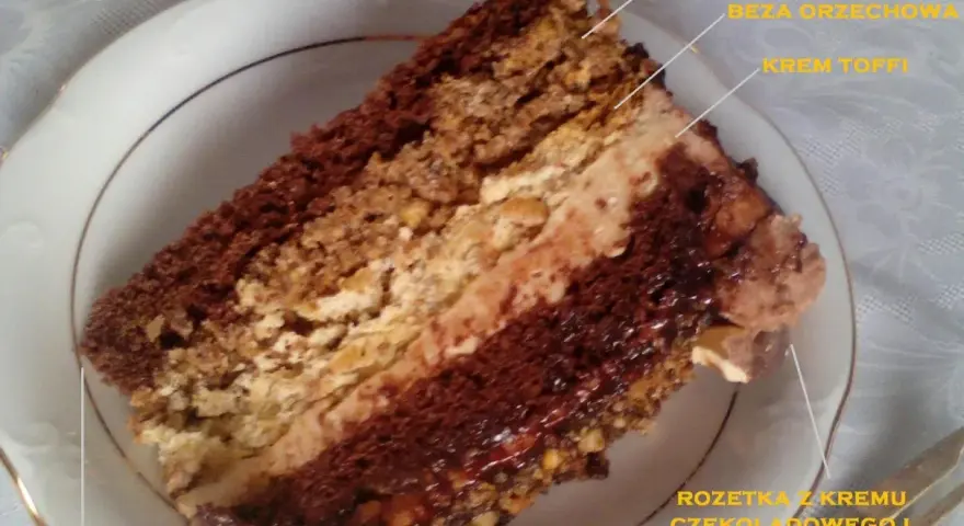 Kawałek tortu toffifee z kremem toffi, bezą orzechową i czekoladą.