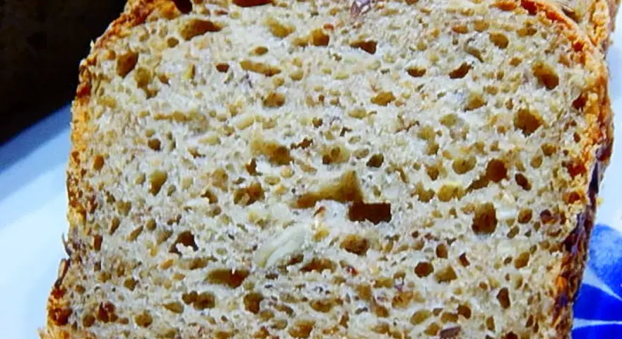 Pyszny chleb żytni na maślance, z widocznymi ziarnami, pokrojony w kromki. Idealny na śniadanie.