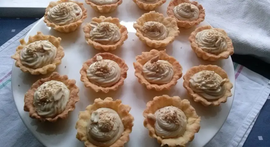 Mini tartaletki z kremem chałwowym, posypane sezamem i orzechami. Idealne na deser.