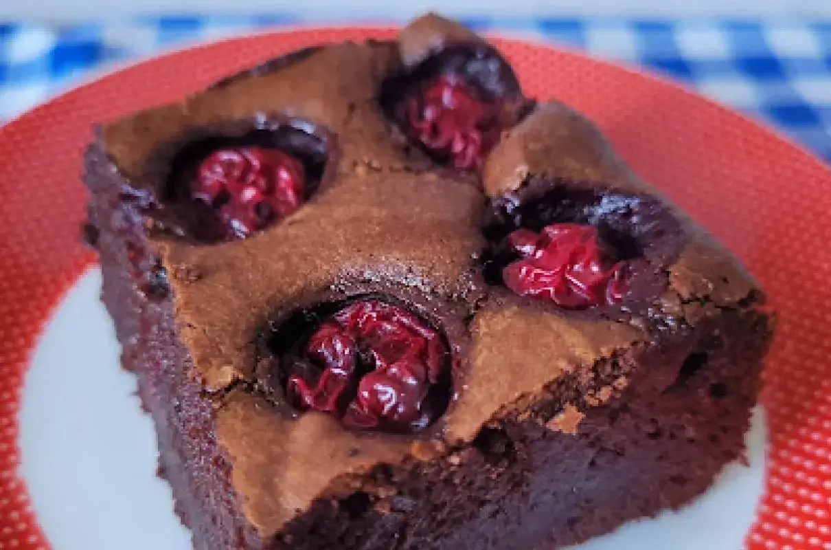 Wilgotny brownie z wiśniami, idealny na deser. Czekoladowe ciasto z kawałkami owoc&oacute;w.